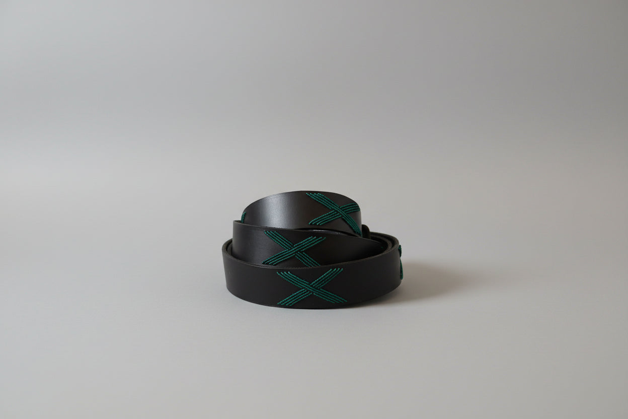 Black belt with green pattern on a light gray background