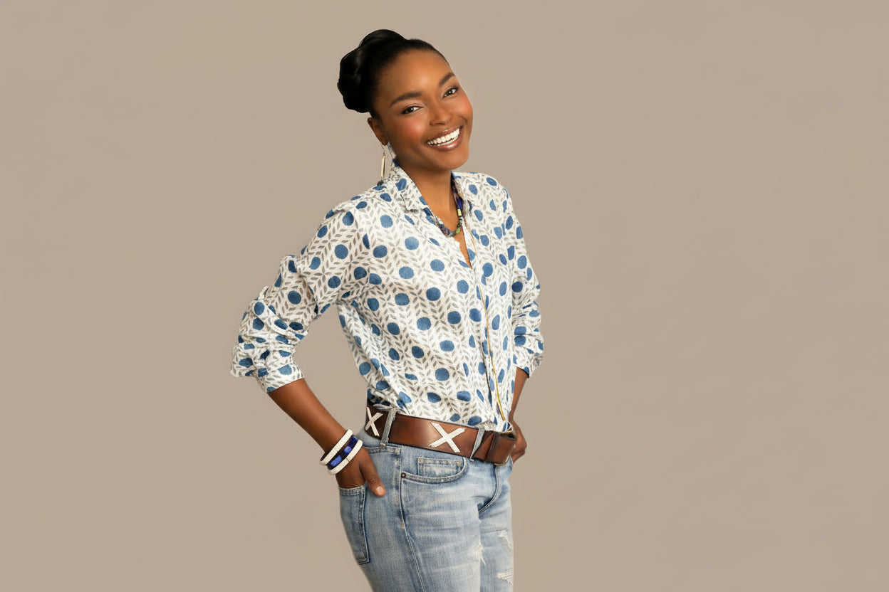 Woman wearing a patterned shirt and jeans on a beige background