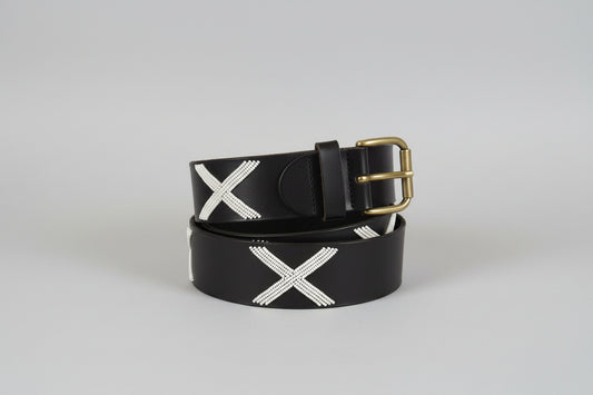 Black belt with white X pattern and gold buckle on a light gray background