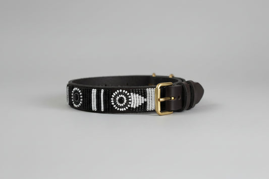 Dark brown leather dog collar with white bead patterns on a grey background