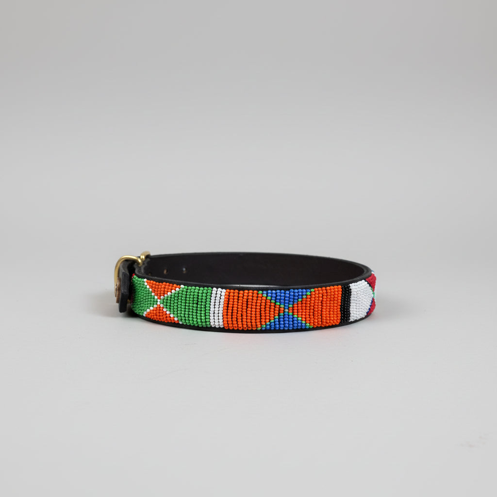 Colorful beaded belt on a beige surface with a blurred indoor background