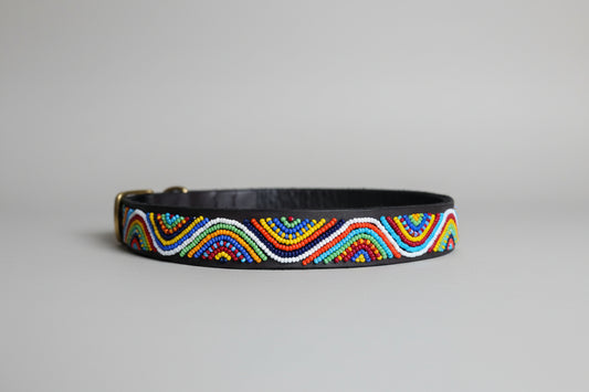 Colorful beaded belt on a beige surface with a blurred indoor background