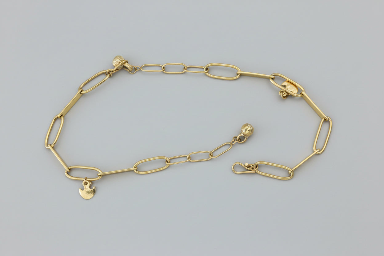Gold chain bracelet on a wooden surface