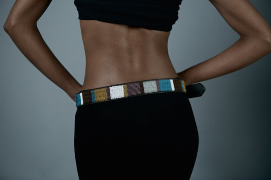 Person wearing a colorful belt with a plain background