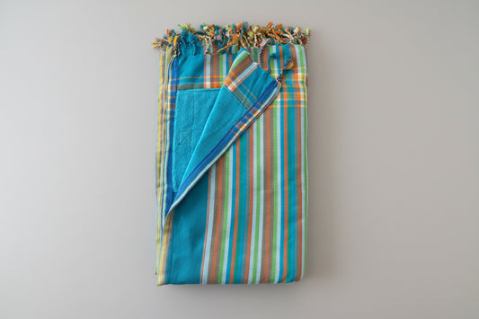 Folded fabric with blue and multicolored striped pattern on a grey background
