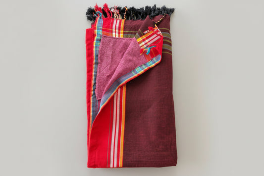 Colourful towel with fringe on a light grey background