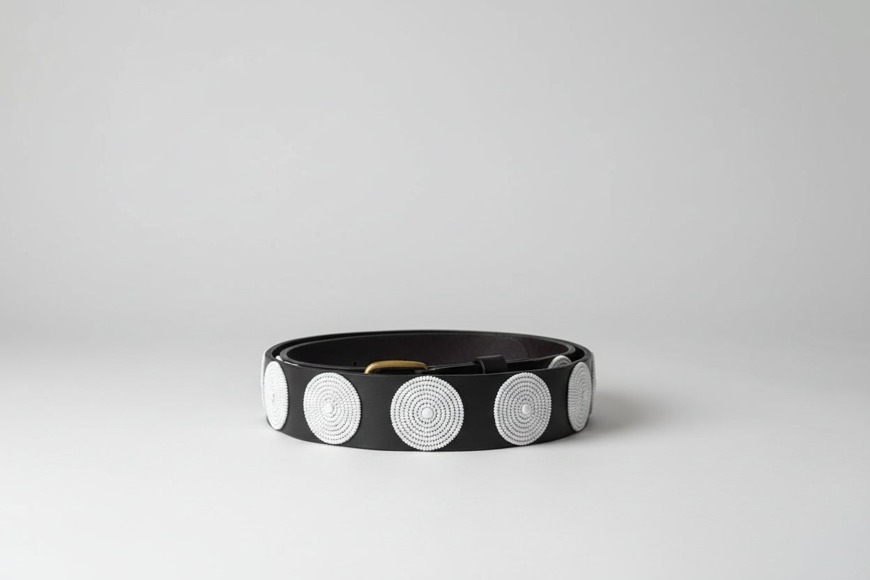 Black belt with white circular patterns on a dark surface